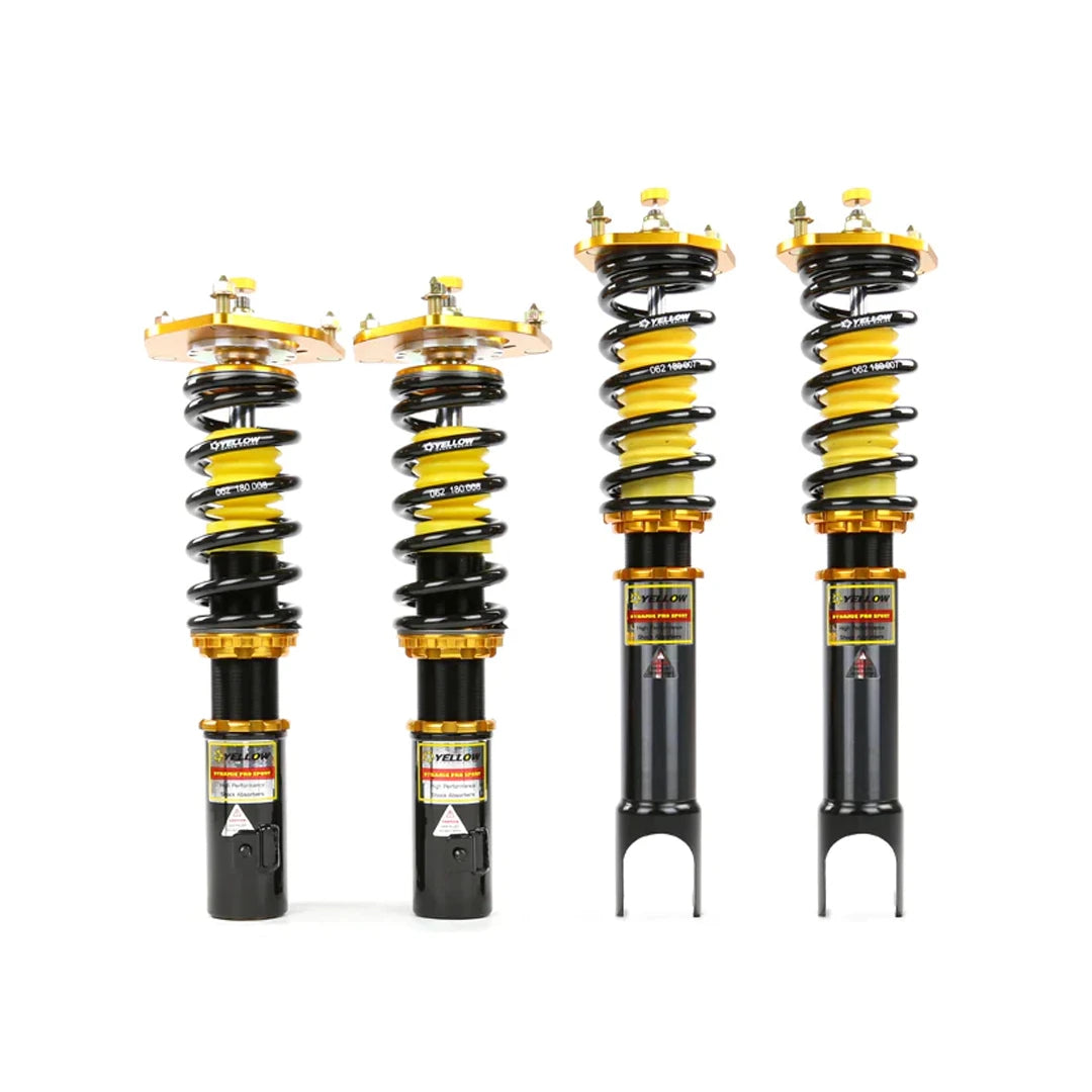 Set of four yellow speed racing coilovers on a white background