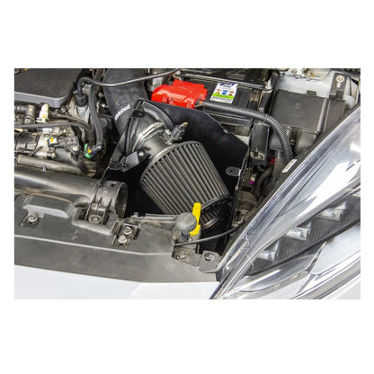 Car engine with a black air filter and red battery