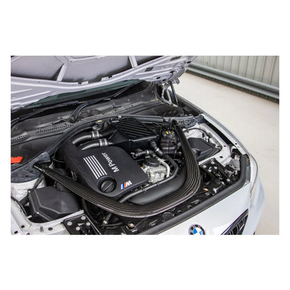 Open car hood revealing a BMW engine with visible branding.