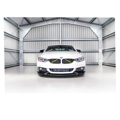 White BMW car in a large, white warehouse.