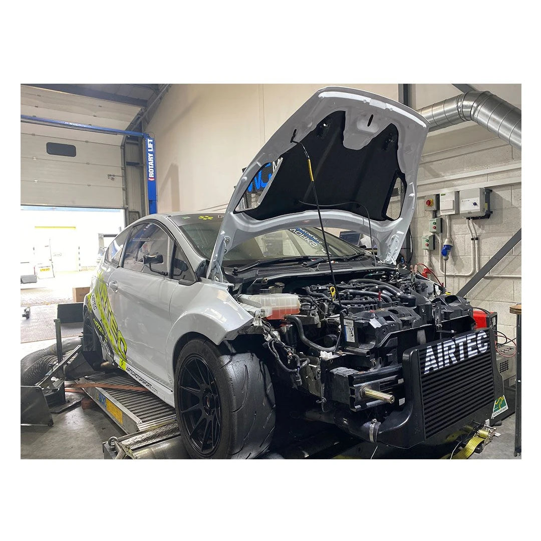 Car on a lift with open hood in a garage, featuring 'Airtec' branding.