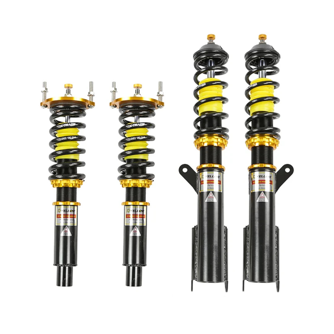 Set of four yellow speed racing coilovers on a white background
